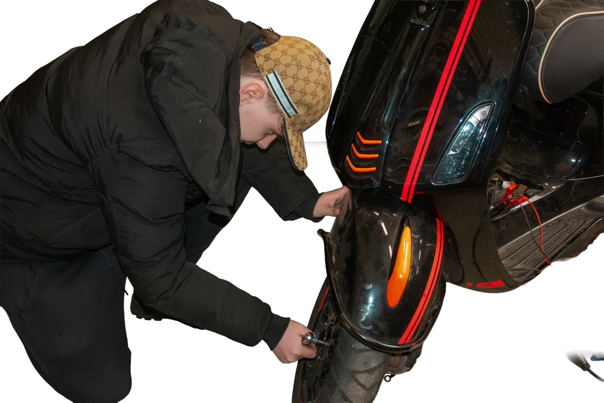Een deelnemer werkt aan een scooter