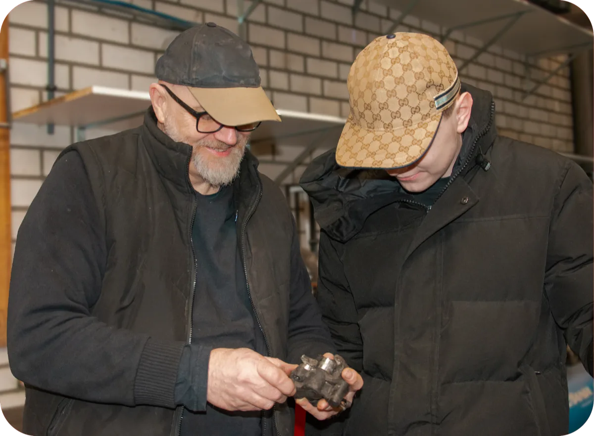 Een begeleider en een deelnemer bekijken samen een onderdeel