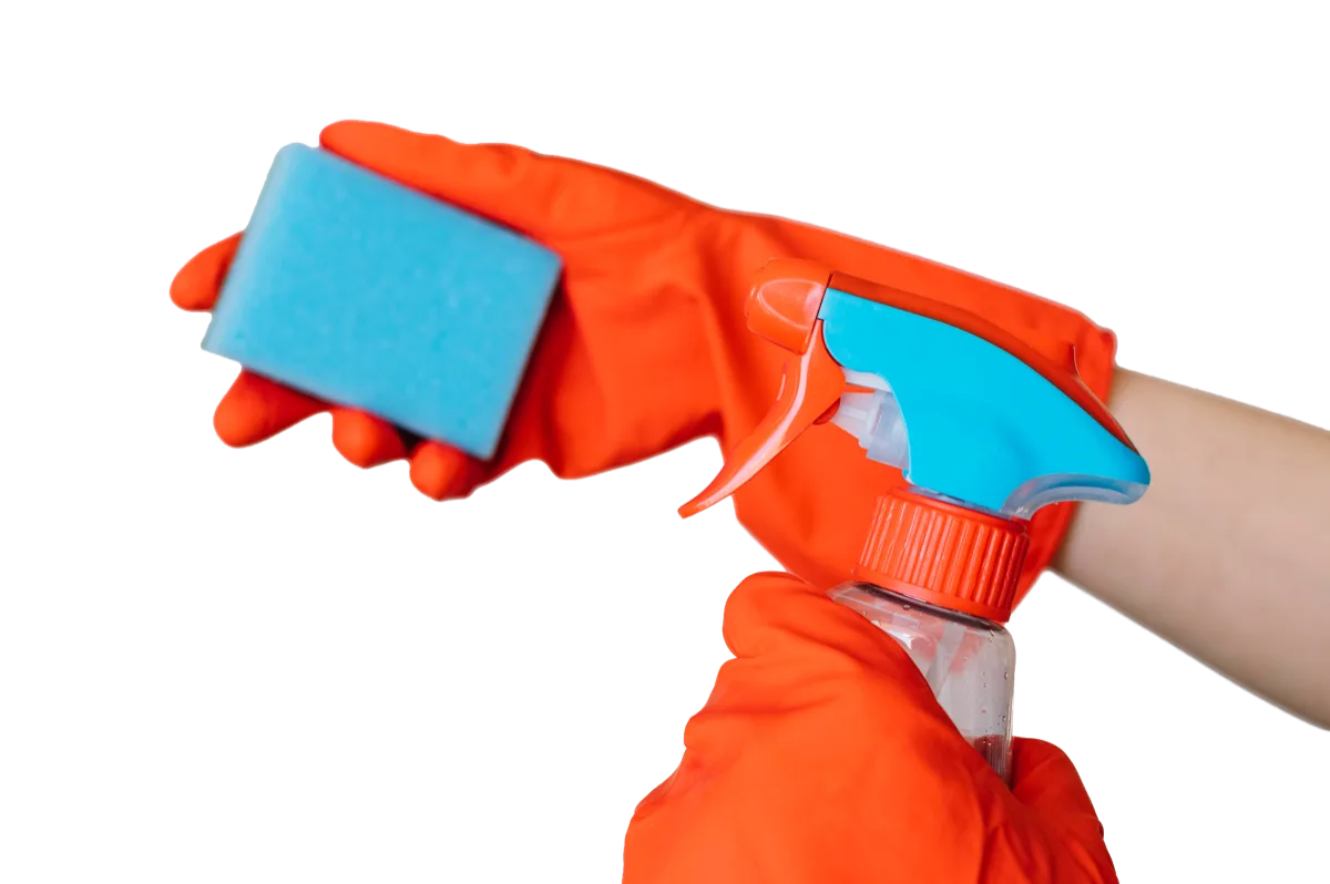 Een hand met een rubberen handschoen houdt een spons en een spuitfles vast